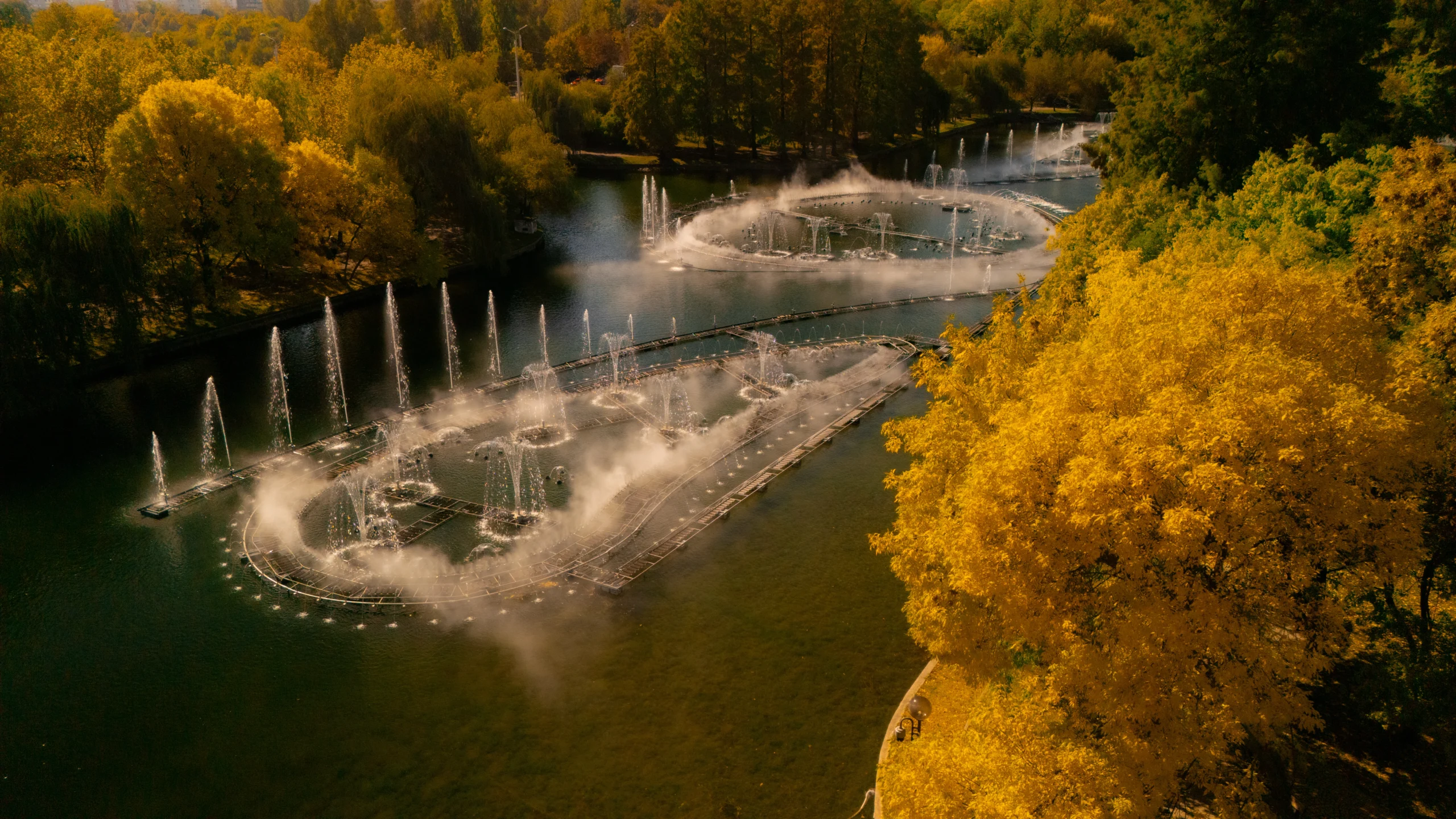 Cadre filmate cu drona în Parcul IOR, București — plan general cu lacul și coroanele de toamnă